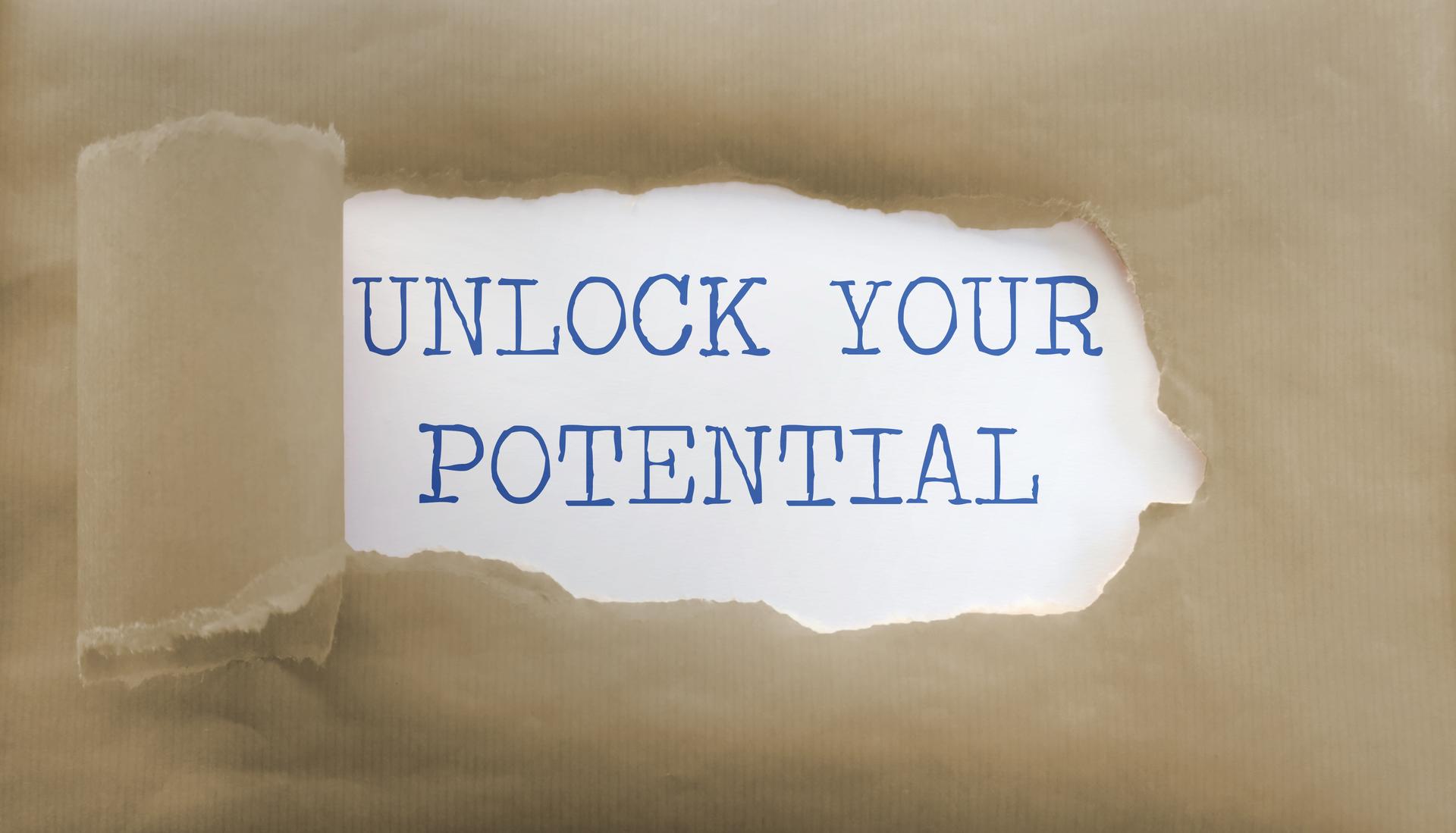 Torn paper with text unlock your potential. Motivation concept, team building, positive thinking, self help, coach (manager, mentor, HR specialist) unlock leader potential and talent